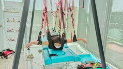Pasien menjalani terapi dengan sling manual therapy system di klinik fisioterapi